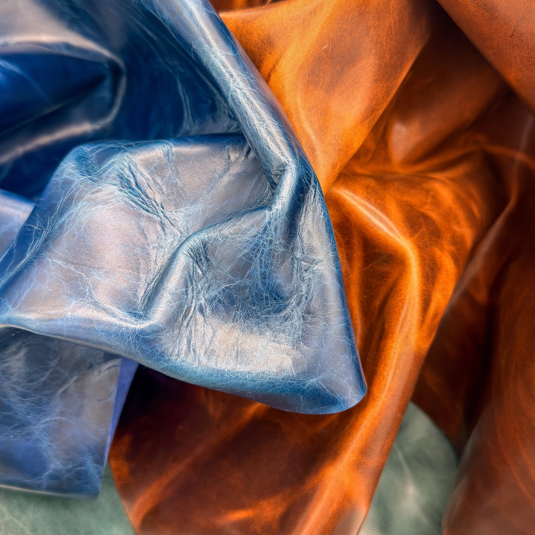 a close up photo of blue, brown, and teal pull-up leather