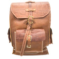 A brown leather backpack with crocodile-embossed and smooth panels, featuring brass-tone buckle closures and white contrast stitching, shown against a plain white background.