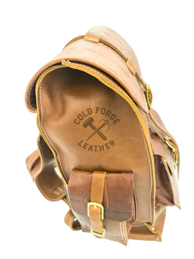 A close-up of a brown leather bag showing the interior side  The bag has a tan crocodile-embossed flap, gold-tone metal hardware, and contrast stitching.