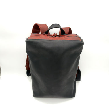 A black leather backpack with reddish trim and top handles, shown from the back on a white background. 